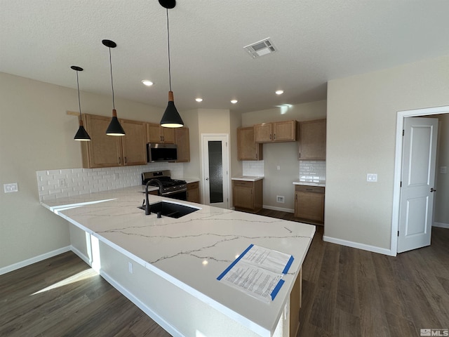 kitchen featuring kitchen peninsula, dark hardwood / wood-style flooring, decorative light fixtures, and appliances with stainless steel finishes