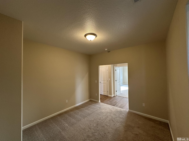 spare room with carpet flooring and a textured ceiling