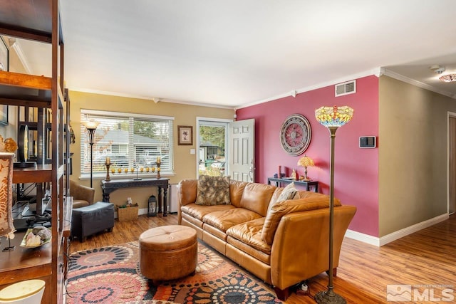 living room featuring ornamental molding and light wood-type flooring