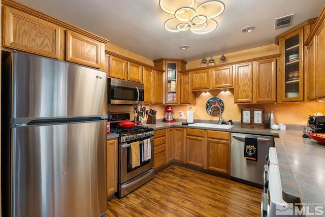 kitchen featuring hardwood / wood-style floors, stainless steel appliances, and sink