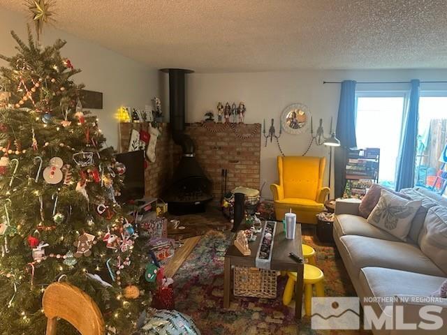 living room with a textured ceiling and a wood stove