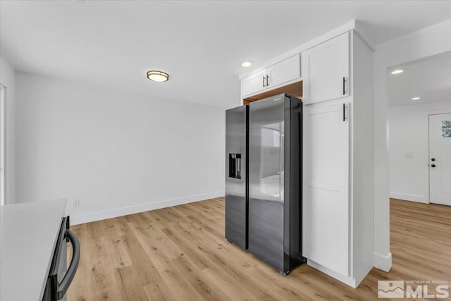 kitchen featuring white cabinets, light hardwood / wood-style flooring, and stainless steel fridge with ice dispenser