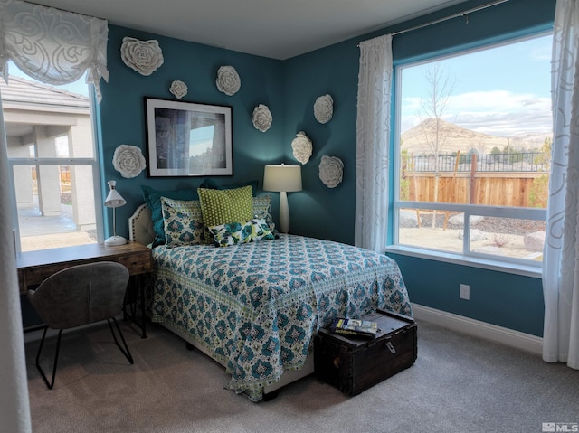 carpeted bedroom with multiple windows and a mountain view