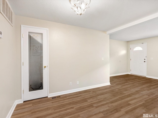 interior space with a textured ceiling and hardwood / wood-style flooring