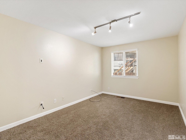 unfurnished room with carpet flooring and track lighting