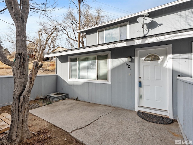 view of exterior entry with a patio