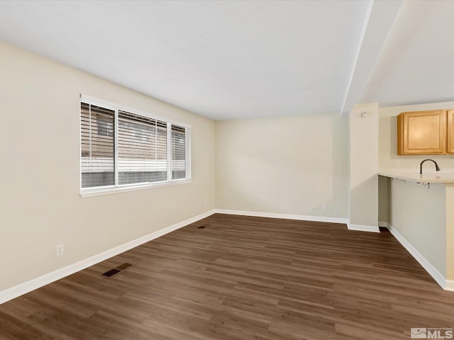 spare room featuring sink and dark wood-type flooring