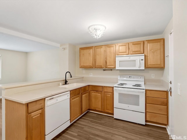 kitchen with kitchen peninsula, sink, dark hardwood / wood-style floors, and white appliances