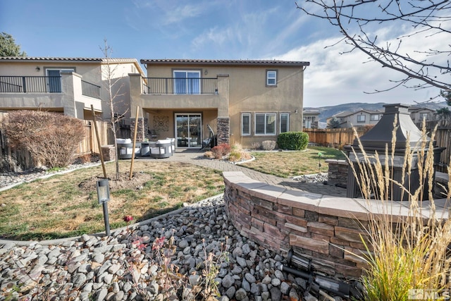 rear view of house featuring a patio area and a balcony