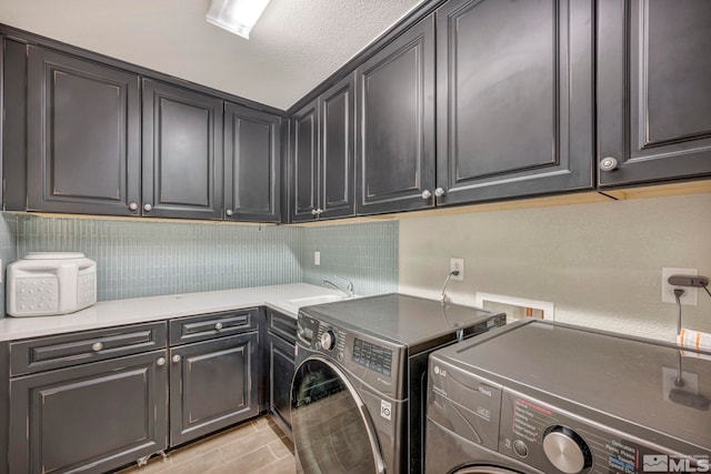 clothes washing area featuring cabinets, separate washer and dryer, light tile patterned flooring, and sink