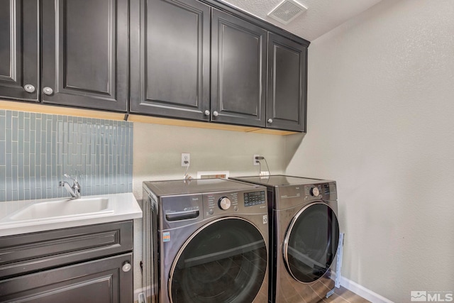 laundry room with cabinets, separate washer and dryer, and sink