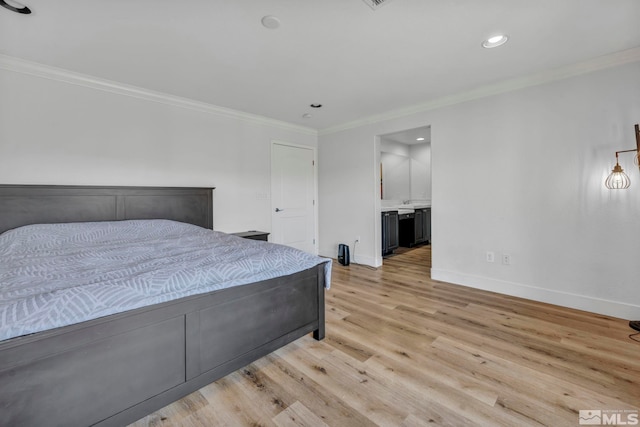 bedroom featuring light hardwood / wood-style floors, crown molding, and ensuite bath