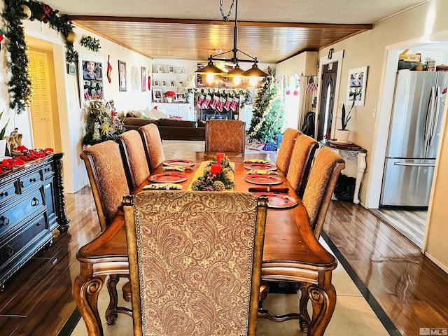 dining area with wood-type flooring, a textured ceiling, and wooden ceiling