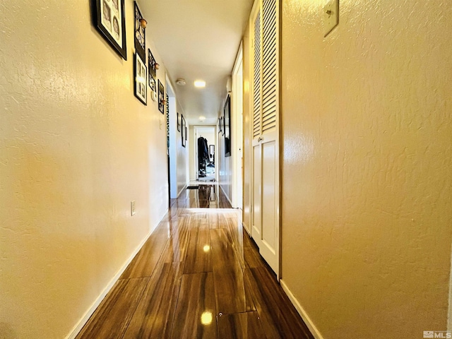 corridor with dark hardwood / wood-style flooring