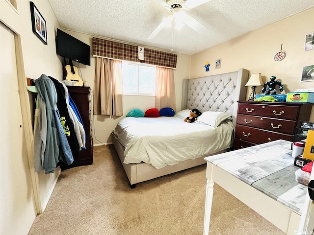 carpeted bedroom featuring ceiling fan and a textured ceiling