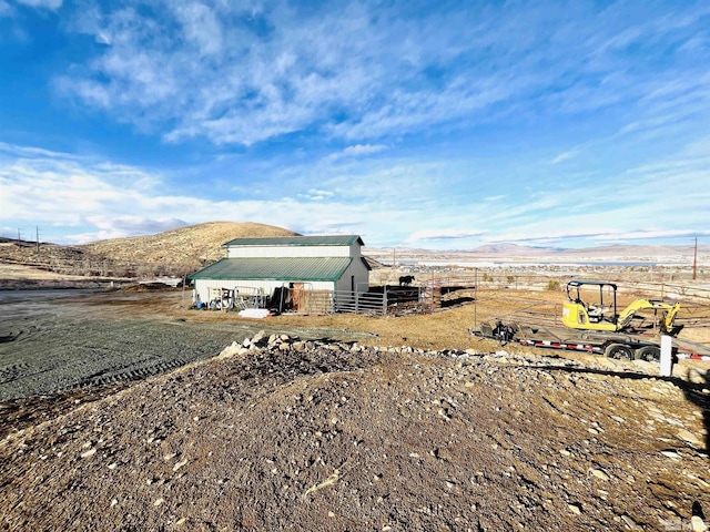 view of yard featuring a mountain view, an outbuilding, and a rural view