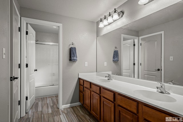 bathroom with vanity, shower / bath combination with glass door, and a textured ceiling