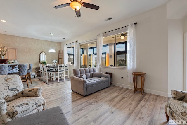 living room with ceiling fan and light hardwood / wood-style flooring