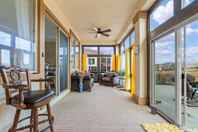 sunroom featuring ceiling fan and a wealth of natural light