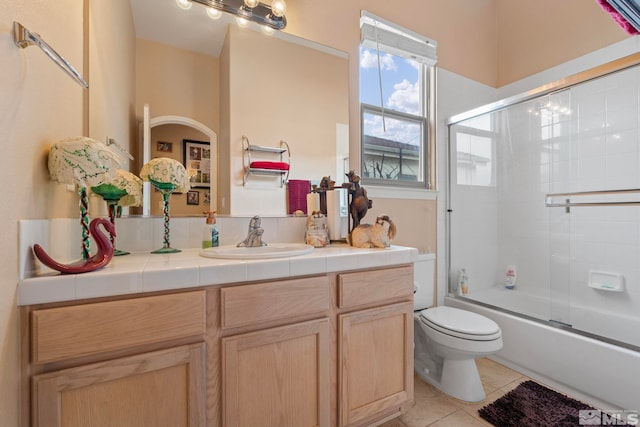 full bathroom with tile patterned floors, vanity, toilet, and bath / shower combo with glass door