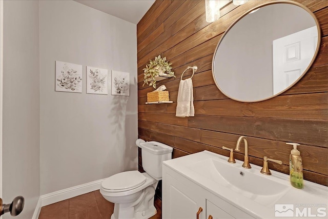 bathroom with tile patterned flooring, vanity, toilet, and wooden walls