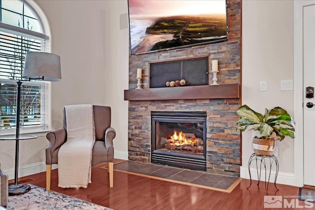 sitting room featuring a healthy amount of sunlight, wood-type flooring, and a fireplace