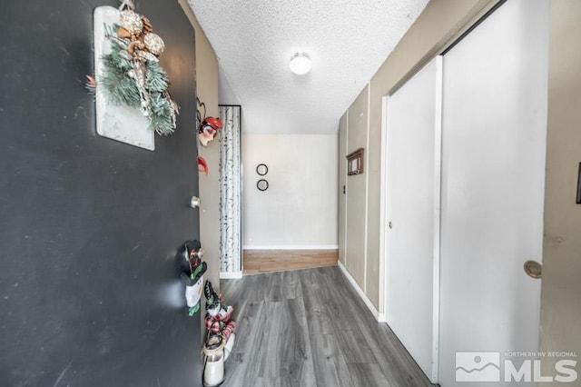 hallway with hardwood / wood-style floors and a textured ceiling