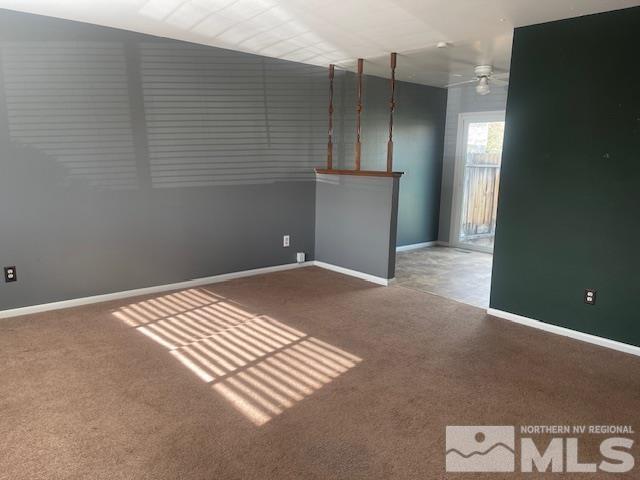 carpeted spare room featuring ceiling fan