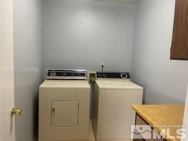 laundry area featuring washer and dryer and light tile patterned flooring