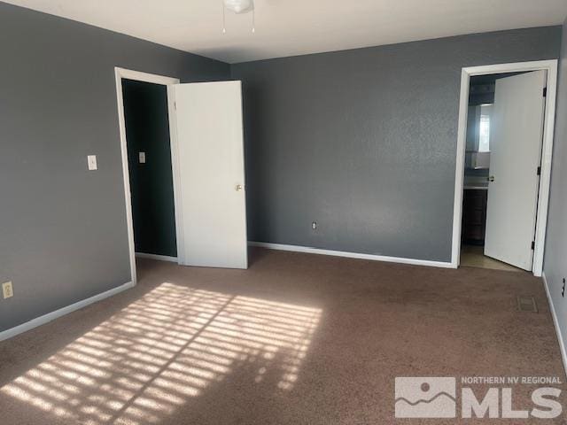 unfurnished bedroom featuring carpet flooring and connected bathroom