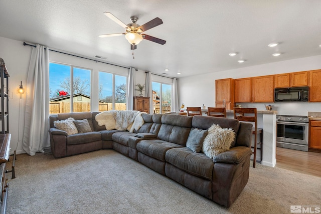 living room with ceiling fan and light carpet