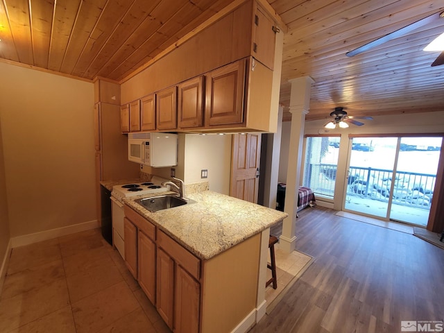 kitchen featuring light stone countertops, sink, wooden ceiling, kitchen peninsula, and white appliances