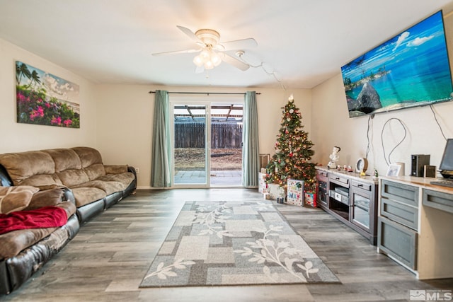 living room featuring ceiling fan and hardwood / wood-style flooring