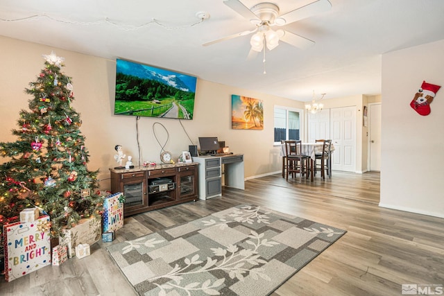 living room with hardwood / wood-style floors and ceiling fan with notable chandelier