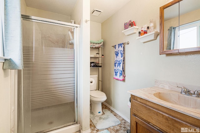 bathroom featuring vanity, toilet, and a shower with shower door