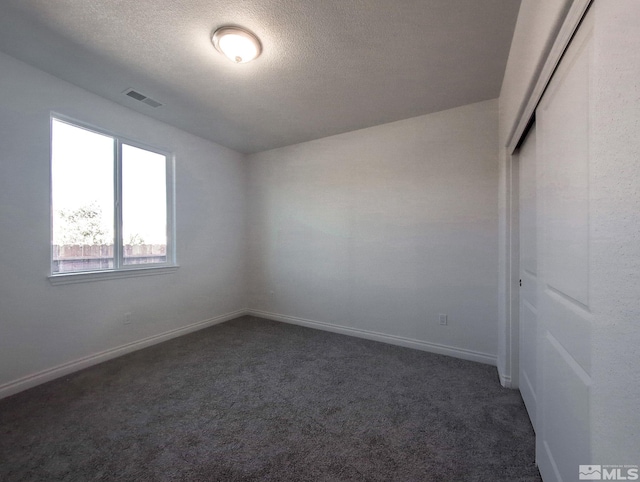 carpeted spare room with a textured ceiling