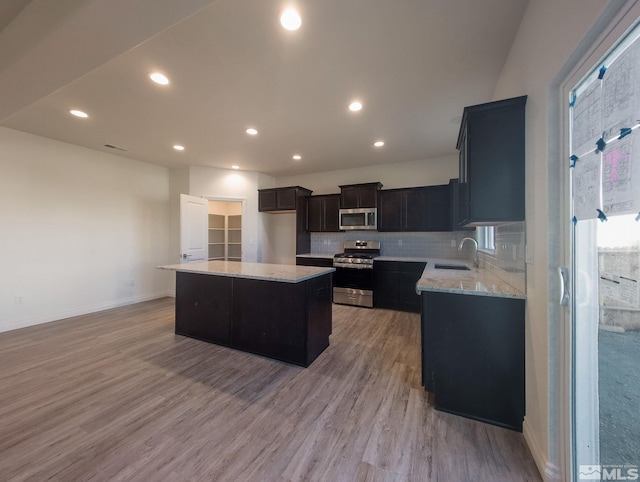 kitchen with sink, a center island, light hardwood / wood-style flooring, and appliances with stainless steel finishes