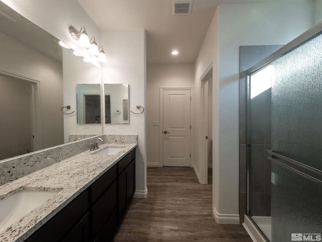 bathroom featuring hardwood / wood-style flooring, vanity, and walk in shower