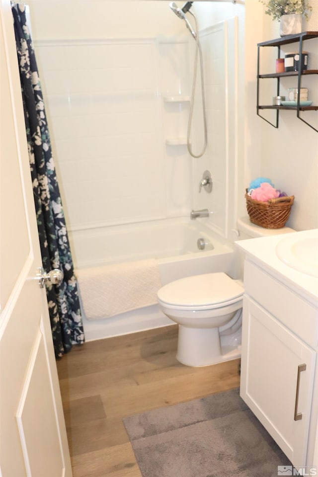 full bathroom with hardwood / wood-style floors, vanity, toilet, and shower / bath combo