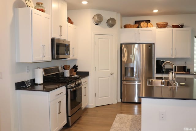 kitchen featuring white cabinets, sink, stainless steel appliances, and light hardwood / wood-style flooring