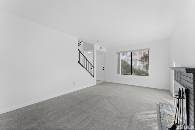 unfurnished living room featuring carpet flooring and a tile fireplace