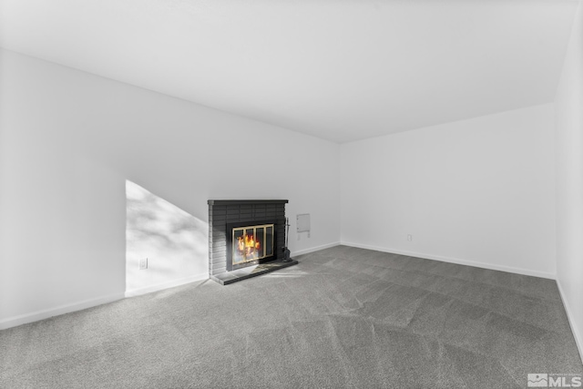 unfurnished living room with carpet flooring and a fireplace