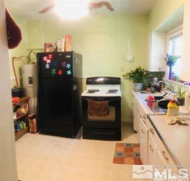 kitchen with white electric range oven, white cabinetry, black refrigerator, and water heater