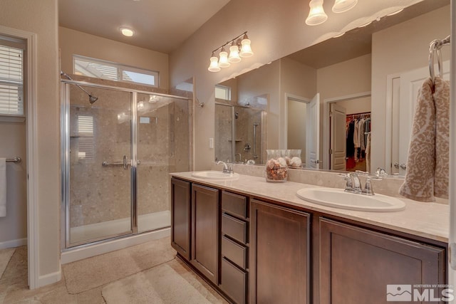 bathroom with tile patterned flooring, vanity, and a shower with door