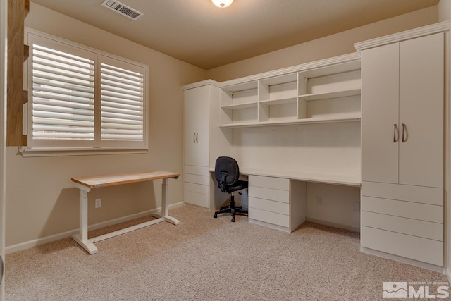 unfurnished office featuring light carpet and built in desk