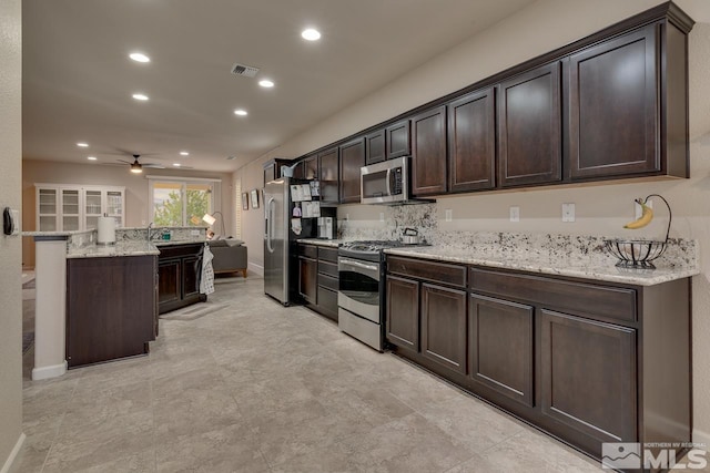 kitchen featuring ceiling fan, dark brown cabinets, and stainless steel appliances