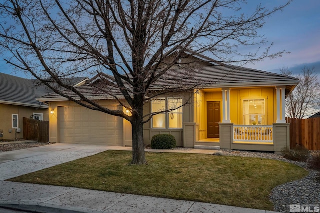 view of front of property featuring a lawn, a porch, and a garage