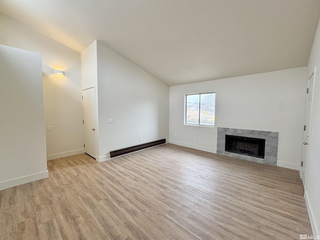 unfurnished living room featuring a baseboard radiator, lofted ceiling, and light hardwood / wood-style floors