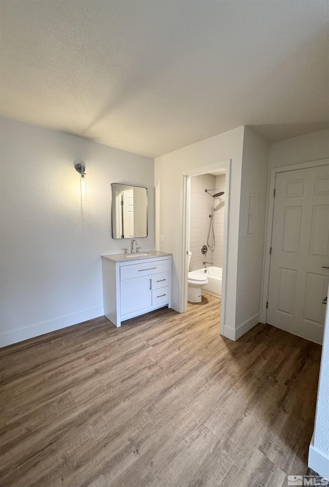 full bathroom with vanity, wood-type flooring,  shower combination, and toilet