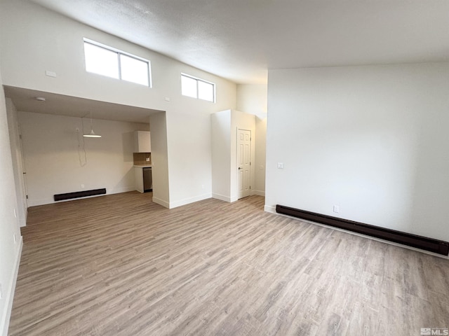 interior space featuring light wood-type flooring and baseboard heating